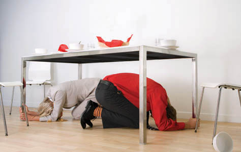 people sheltering under desk