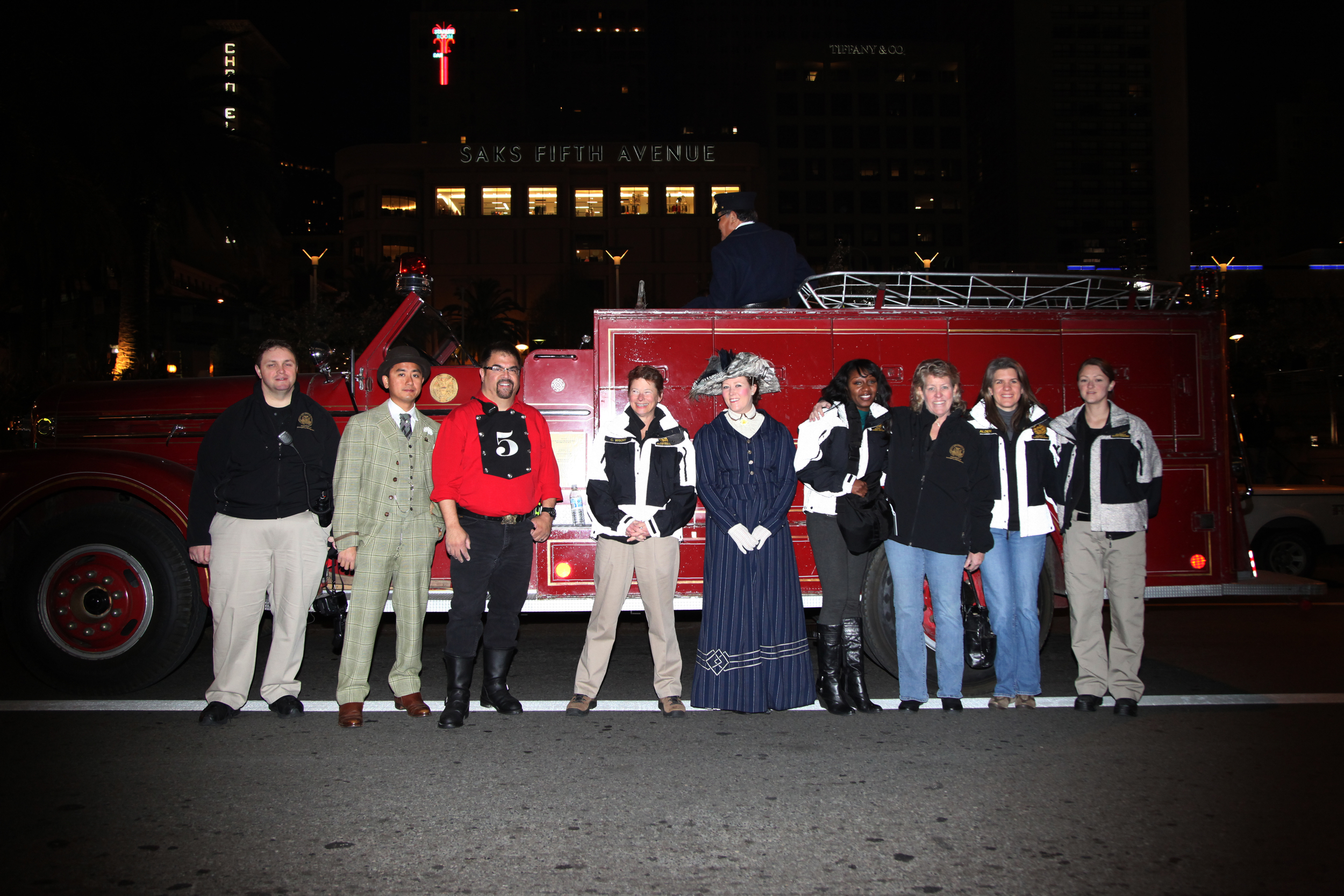 people in period dress next to firetruck
