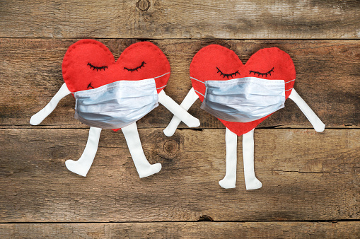 Image of two felt hearts with face masks as part of Valentine's Day COVID-19 safety message.